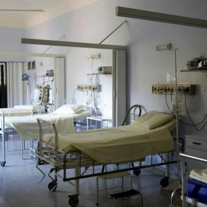 Spacious hospital room with several empty beds and medical equipment, emphasizing healthcare and hygiene.