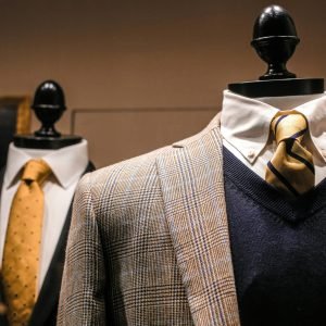 Dandy fancy jackets with shiny ties on dummies in showroom of contemporary male shop